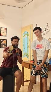 a man taking a picture of another man in a mirror at The Hostel Stories, Varkala - Helipad Road in Varkala