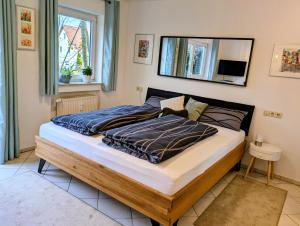 a bed in a bedroom with a mirror on the wall at Appartement Mettenberg in Biberach an der Riß