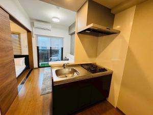 une cuisine avec un évier et une cuisinière dans l'établissement LuxurySweet 博多駅南61, à Fukuoka