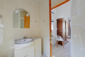 a bathroom with a sink and a mirror and a chair at Gîtes Tautavel in Tautavel +62 photos