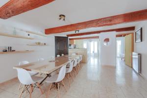 a large dining room with a wooden table and white chairs at Gîtes Tautavel in Tautavel