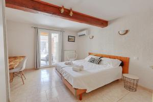 a bedroom with a large bed and a balcony at Gîtes Tautavel in Tautavel