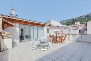 a patio with a table and chairs and an umbrella at Gîtes Tautavel in Tautavel
