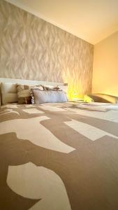 a bedroom with a large bed with a wall at Appartement en centre-ville in Briey