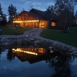 a house lit up at night with a reflection in the water at Grand Chalet in Bourbon-Lancy