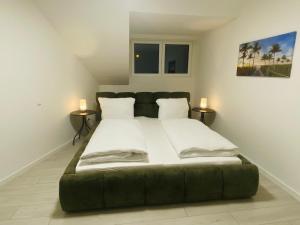 a large bed in a room with two tables at Anacoco Deluxe Home in Herzogenrath