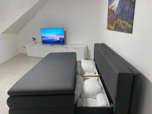 a living room with a couch and a tv at Anacoco Deluxe Home in Herzogenrath