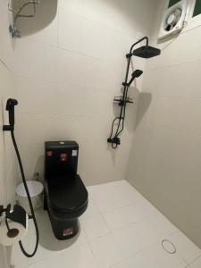 a bathroom with a black toilet and a shower at نزل Rest in Hail
