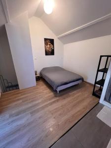 a bedroom with a bed and a wooden floor at Maison T2 in Bonny-sur-Loire