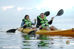 Zwei Frauen sitzen in einem Kajak auf dem Wasser. in der Unterkunft Isla Enriqueta - Private Beach Resort in Iba