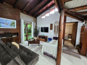 a living room with a couch and a tv at Casa de praia com piscina e jacuzzi totalmente privativa in Imbituba