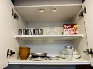 eine Küche mit Regalen mit Töpfen und Pfannen in der Unterkunft LuxurySweet 博多駅南62 in Fukuoka