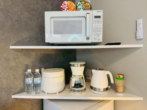 eine Mikrowelle auf einem Regal in der Unterkunft LuxurySweet 博多駅南62 in Fukuoka
