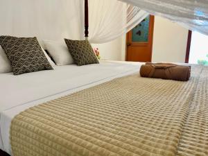 um quarto com uma cama grande e um edredão grande em The Golden Sand Villa in Unawatuna em Unawatuna