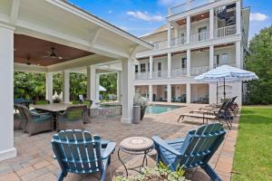 eine Terrasse mit Stühlen, einem Tisch und einem Sonnenschirm in der Unterkunft CM3008: 3008 Cameron Blvd. in Isle of Palms