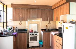 a kitchen with wooden cabinets and a white stove top oven at Namaste Bnb in Yanahuara