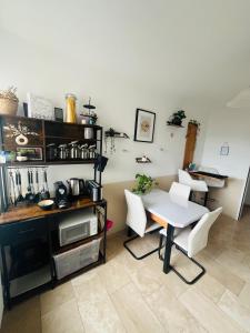 a kitchen with a table and white chairs in a room at Wunderschöne helle große Wohnung in Größing +11 photos