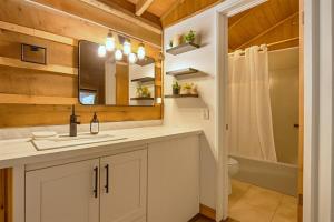 Un baño con lavabo, inodoro y espejo. en Wooden suite #2, en Madill