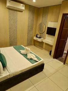 a room with a bed with a towel animal on it at The Silk Route Hotel in Panchkula +12 photos