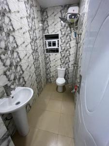 un baño con inodoro y lavabo en House 40 Residence - Gold Mini Flat, en Ibadán