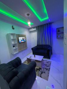 Una sala de estar con un sofá y una mesa y luces verdes. en House 40 Residence - Gold Mini Flat, en Ibadán 12 fotos más