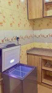 Una cocina con un lavavajillas con una caja azul dentro. en House 40 Residence - Gold Mini Flat, en Ibadán