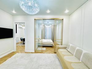 a living room with a couch and a bedroom at Respublica Luxe apart in Astana
