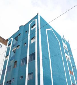 a blue building with white stripes on the side of it at HÔTEL Michou in Bafoussam