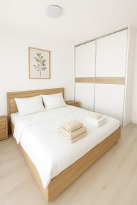 コシツェにある4-Quiet Apartment - 8 min from the center New buildingの白いベッドルーム(大型ベッド、タオル付) +11枚の写真