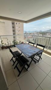 une table et des chaises sur un balcon avec vue dans l'établissement Lindo apto com vista para o mar, à Guarujá