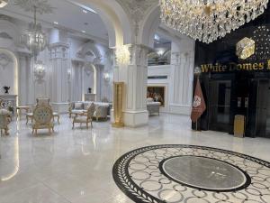 a large room with a chandelier and a white dance floor at White Domes Hotel in Baghdād