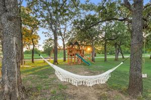 a hammock in a park with a playground at Wooden suite #5 in Madill