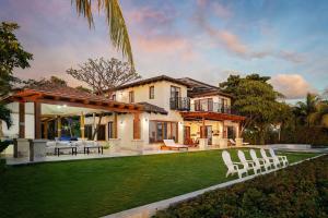 a house with a yard with white lawn chairs at Casa Colorados in Tola