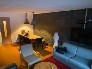 a living room with a couch and a dining room table at 4 Valleys Ski In in Nendaz