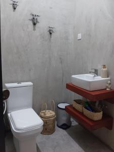 a bathroom with a white toilet and a sink at Nyumbani House in Mto wa Mbu