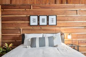 a bedroom with a bed with four pictures on the wall at Wooden Suite #6 in Madill