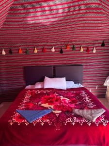 une chambre avec un grand lit recouvert d'une couverture rouge dans l'établissement Star Walk Camp & Tours, à Wadi Rum