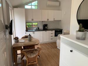 a kitchen with white cabinets and a table with chairs at Enjoy nature in silence in Ljungen