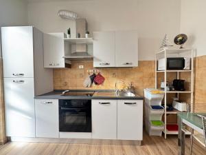 a kitchen with white cabinets and a sink at Bilocale luminoso ed elegante-Parcheggio gratuito in La Spezia +18 photos