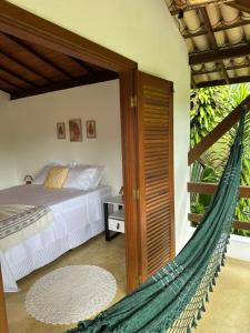 une chambre avec un lit et un hamac dans l'établissement Pousada ViniCarmel Arraial d ajuda, à Arraial d'Ajuda 43 autres photos