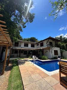 une image d'une maison avec piscine dans l'établissement Pousada ViniCarmel Arraial d ajuda, à Arraial d'Ajuda