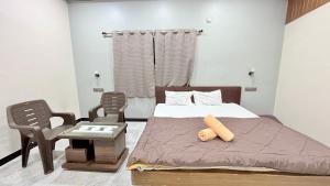 a bedroom with a bed and a table and chairs at Swara Homestay in Bārsiv +5 photos
