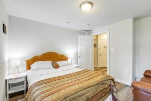 ein weißes Schlafzimmer mit einem großen Bett und einem Stuhl in der Unterkunft Suburban Comfort in Bowie! Apartment with Patio in Bowie