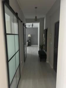 un couloir vide avec une porte vitrée dans un salon dans l'établissement DianaS Home, à Craiova 4 autres photos