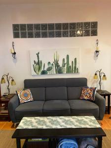 a living room with a couch and a cactus painting on the wall at The Garden Apartment at The Hacienda in Boquete