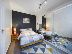 a bedroom with two beds and a black wall at L'incontournable de Paris la Défense in Puteaux