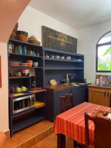 a kitchen with blue cabinets and a table with a microwave at The Garden Apartment at The Hacienda in Boquete
