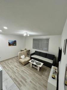 una sala de estar con un sofá y una mesa en Apartman M, 