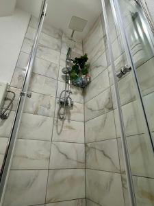 y baño con ducha y azulejos de mármol. en Apartman M,  11 fotos más