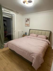 a bedroom with a large bed with pink pillows at Ins apartment - 2 bedrooms - metro parking prive in Bagnolet
